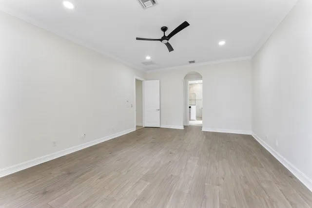 wooden floor in an empty room with a ceiling fan