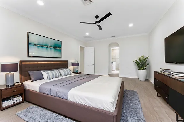 a bedroom with a large bed and a flat screen tv