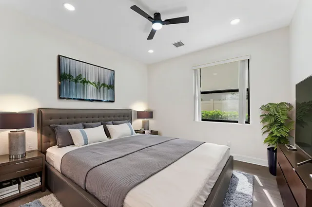 a bedroom with a large bed and a potted plant