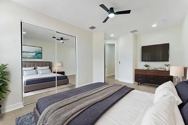 a bedroom with a bed flat screen tv and a couch