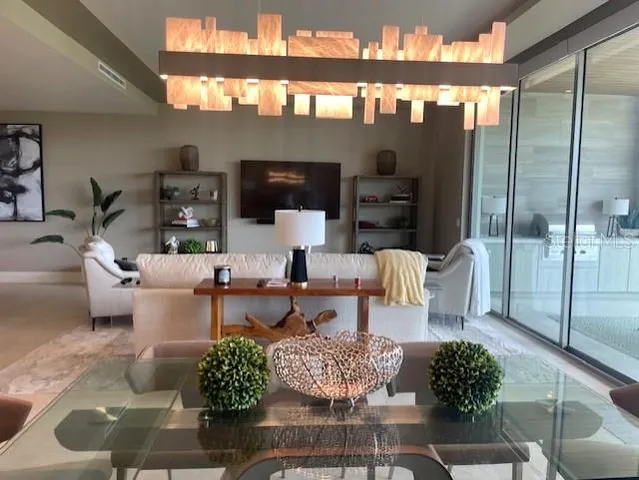 a living room with furniture a rug and kitchen view