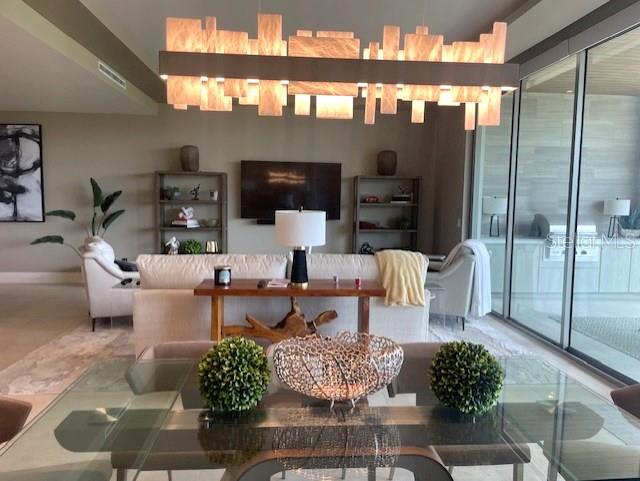 1581 Gulf Of Mexico Drive, Unit 307 Longboat Key, FL 34228 - Photo 16 of 83 a living room with couches a flat screen tv and kitchen view