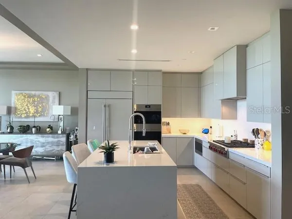 a kitchen with kitchen island a sink a stove and wooden cabinets