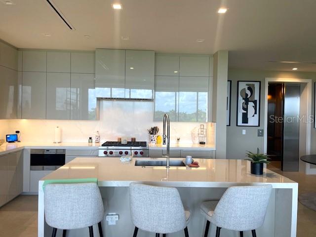 1581 Gulf Of Mexico Drive, Unit 307 Longboat Key, FL 34228 - Photo 8 of 83 a kitchen with a table chairs sink and cabinets