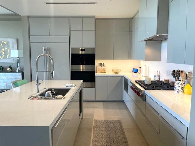 1581 Gulf Of Mexico Drive, Unit 307 Longboat Key, FL 34228 - Photo 10 of 83 a kitchen with kitchen island a sink a stove and wooden cabinets