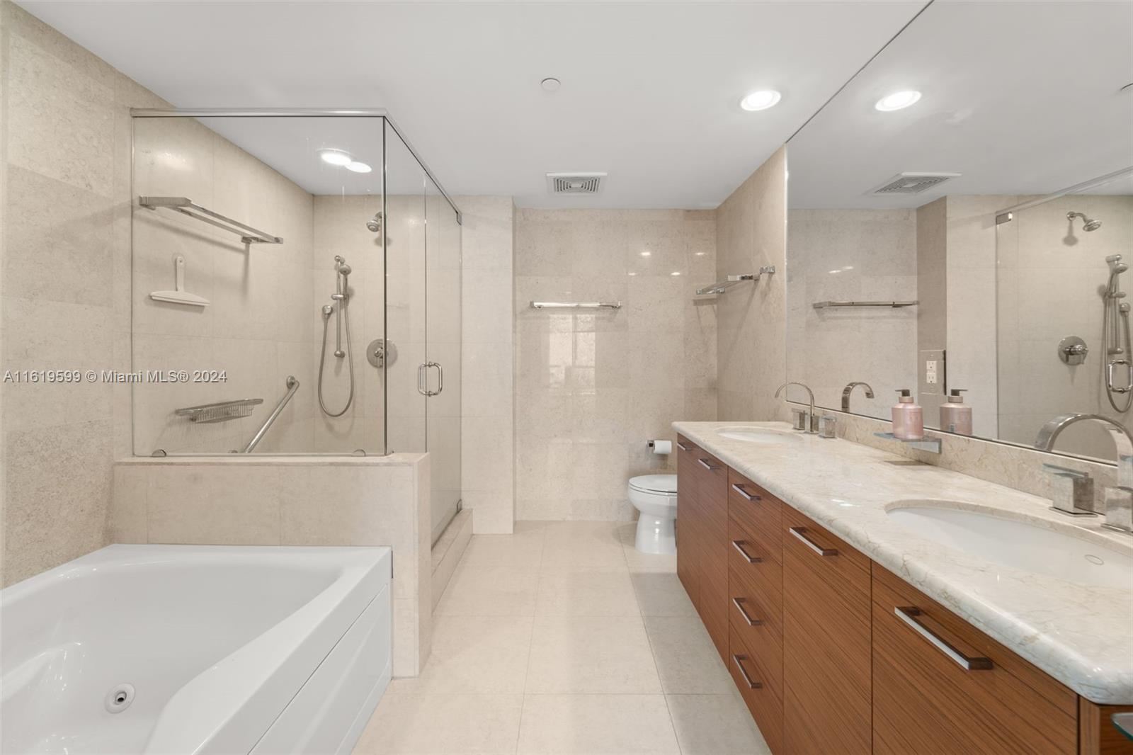 50 Biscayne Boulevard, Unit 4802 Miami, FL 33132 - Photo 14 of 27 a bathroom with a tub sink shower and two mirror