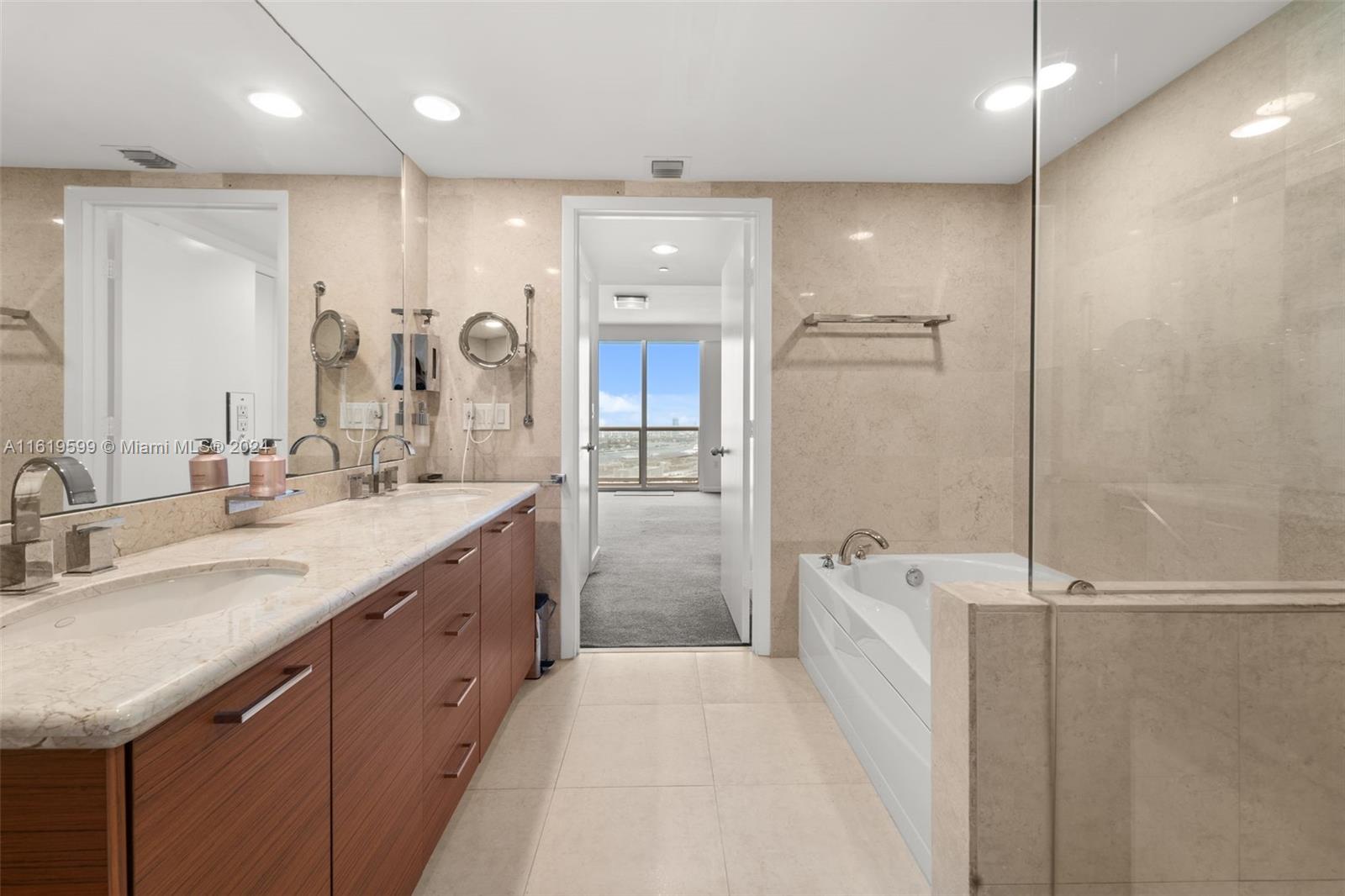 50 Biscayne Boulevard, Unit 4802 Miami, FL 33132 - Photo 15 of 27 a spacious bathroom with a sink a toilet a shower and a mirror