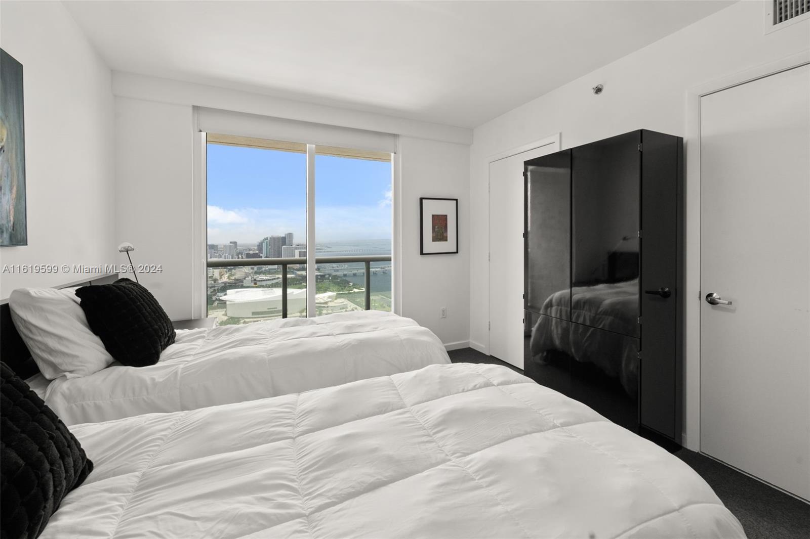 50 Biscayne Boulevard, Unit 4802 Miami, FL 33132 - Photo 20 of 27 a bedroom with a bed and a window