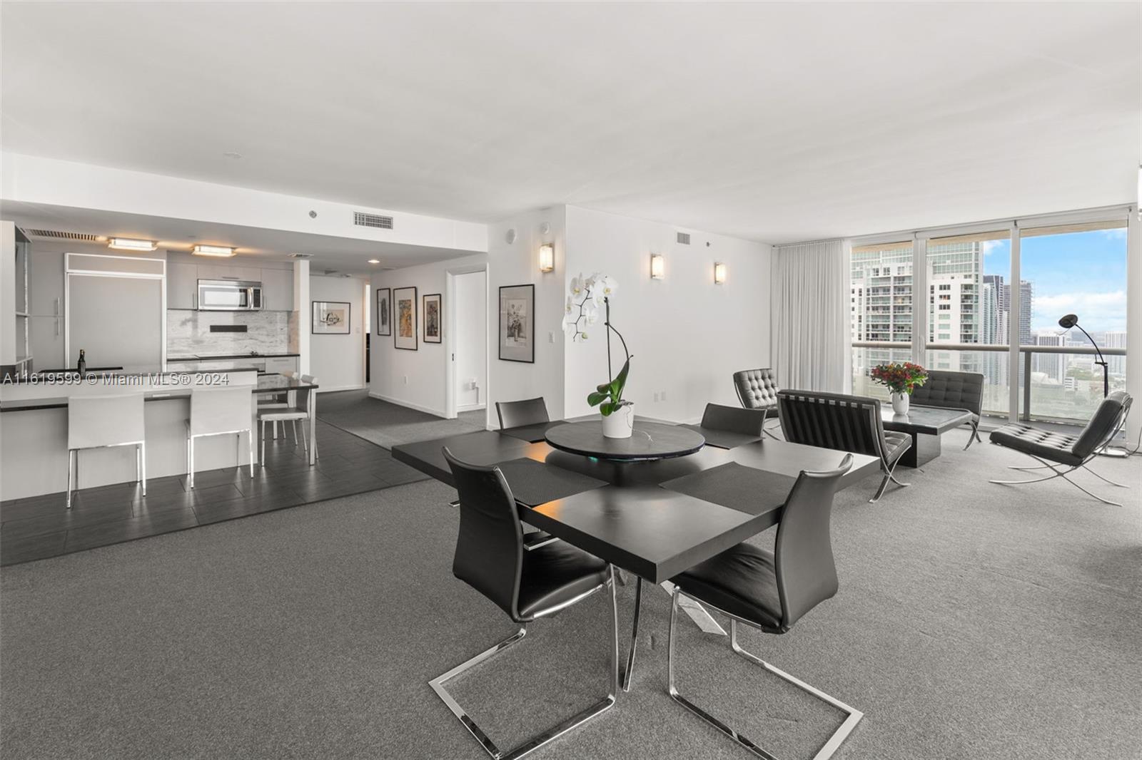 50 Biscayne Boulevard, Unit 4802 Miami, FL 33132 - Photo 4 of 27 a living room with furniture a table and kitchen view