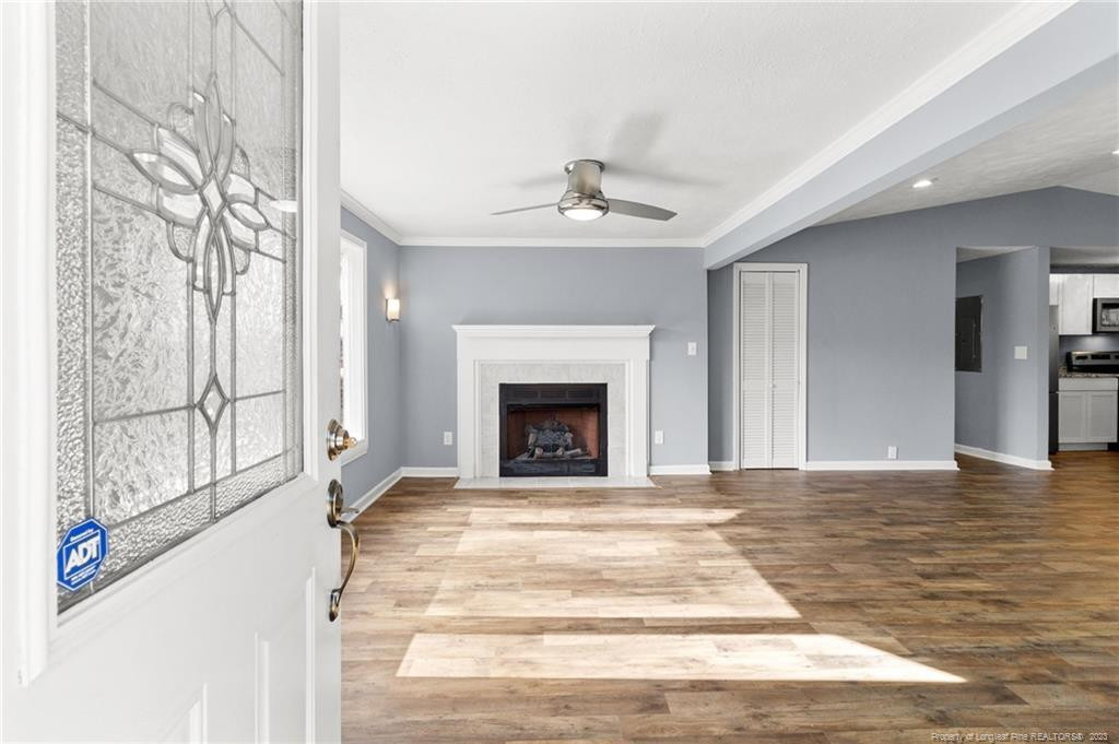 8424 King Road Fayetteville, NC 28306 - Photo 6 of 35 a view of a livingroom with a fireplace a ceiling fan and windows