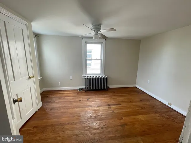 an empty room with wooden floor and window