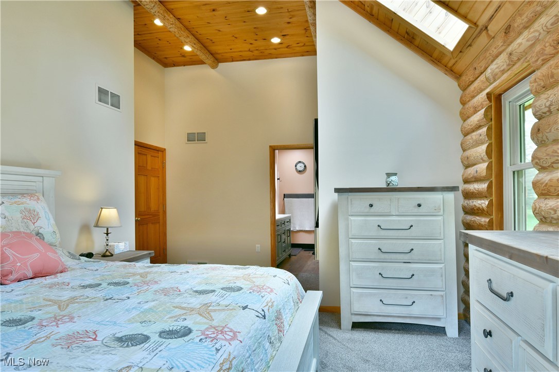 2907 Bushnell Campbell Road Fowler, OH 44418 - Photo 26 of 49 Bedroom featuring wooden ceiling, high vaulted ceiling, a skylight, light carpet, and rustic walls