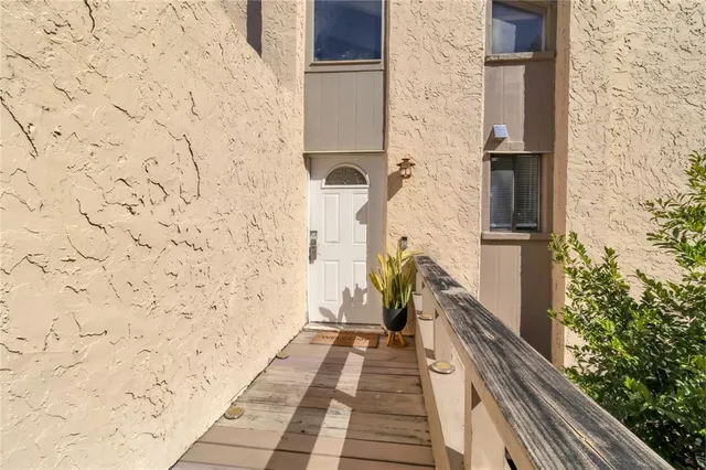 a hallway with wooden floor and a potted plant