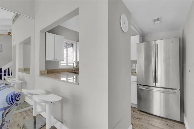 a kitchen with stainless steel appliances a refrigerator and a stove with wooden floor