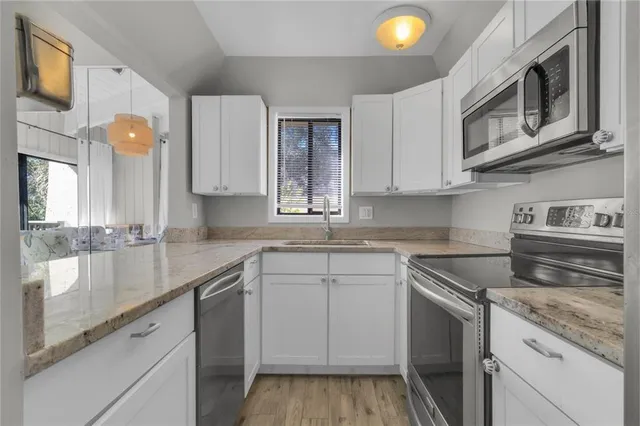 a kitchen with stainless steel appliances granite countertop a sink and a stove