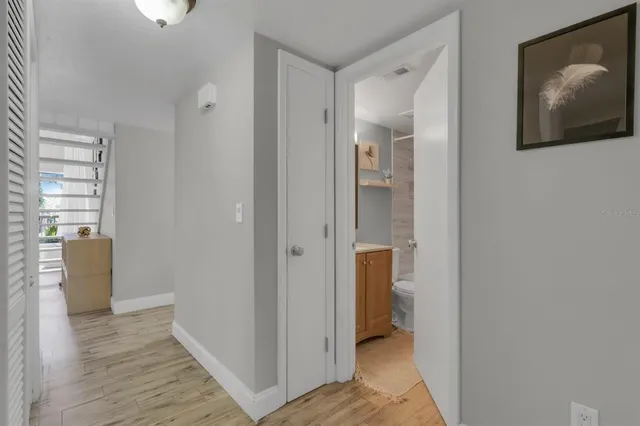 a view of a hallway with wooden floor and closet