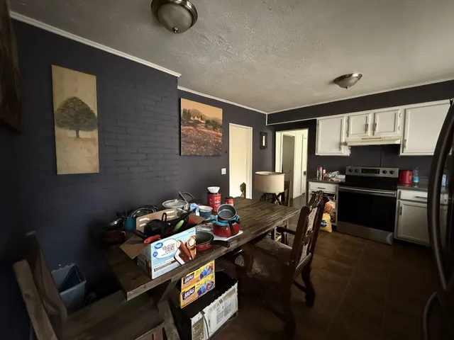 a kitchen with a table chairs stove and refrigerator