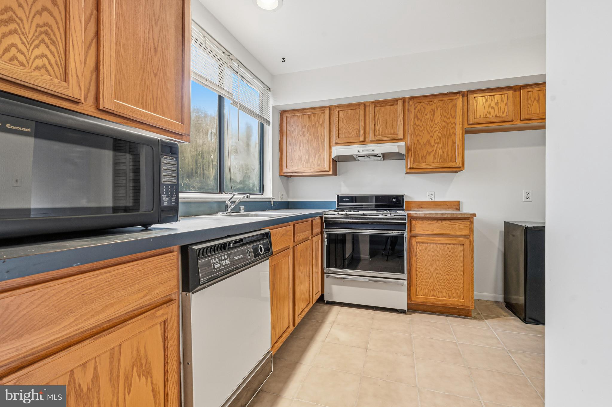 6 Stone Ridge Court, Unit 29 Baltimore, MD 21239 - Photo 6 of 26 a kitchen with stainless steel appliances granite countertop a stove a sink and a microwave