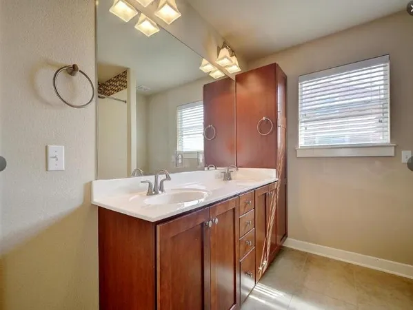 an empty room with chandelier fan and windows