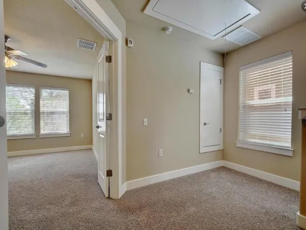 an empty room with closet and a ceiling fan