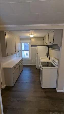 a kitchen with a sink and wooden floor