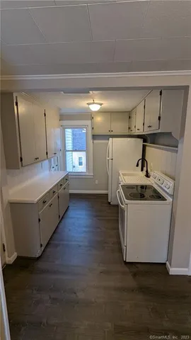 a kitchen with a sink and wooden floor
