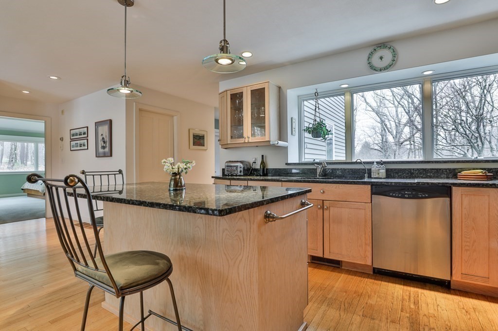 68 Slough Road Harvard, MA 01451 - Photo 15 of 35 a kitchen with granite countertop a table chairs stove and cabinets