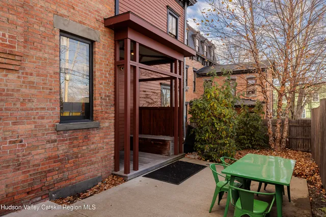 a view of backyard with a table and chairs and potted plants