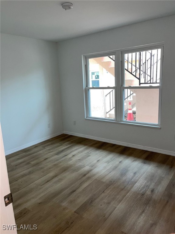 16881 Davis Road, Unit 713 Fort Myers, FL 33908 - Photo 11 of 29 an empty room with wooden floor and windows