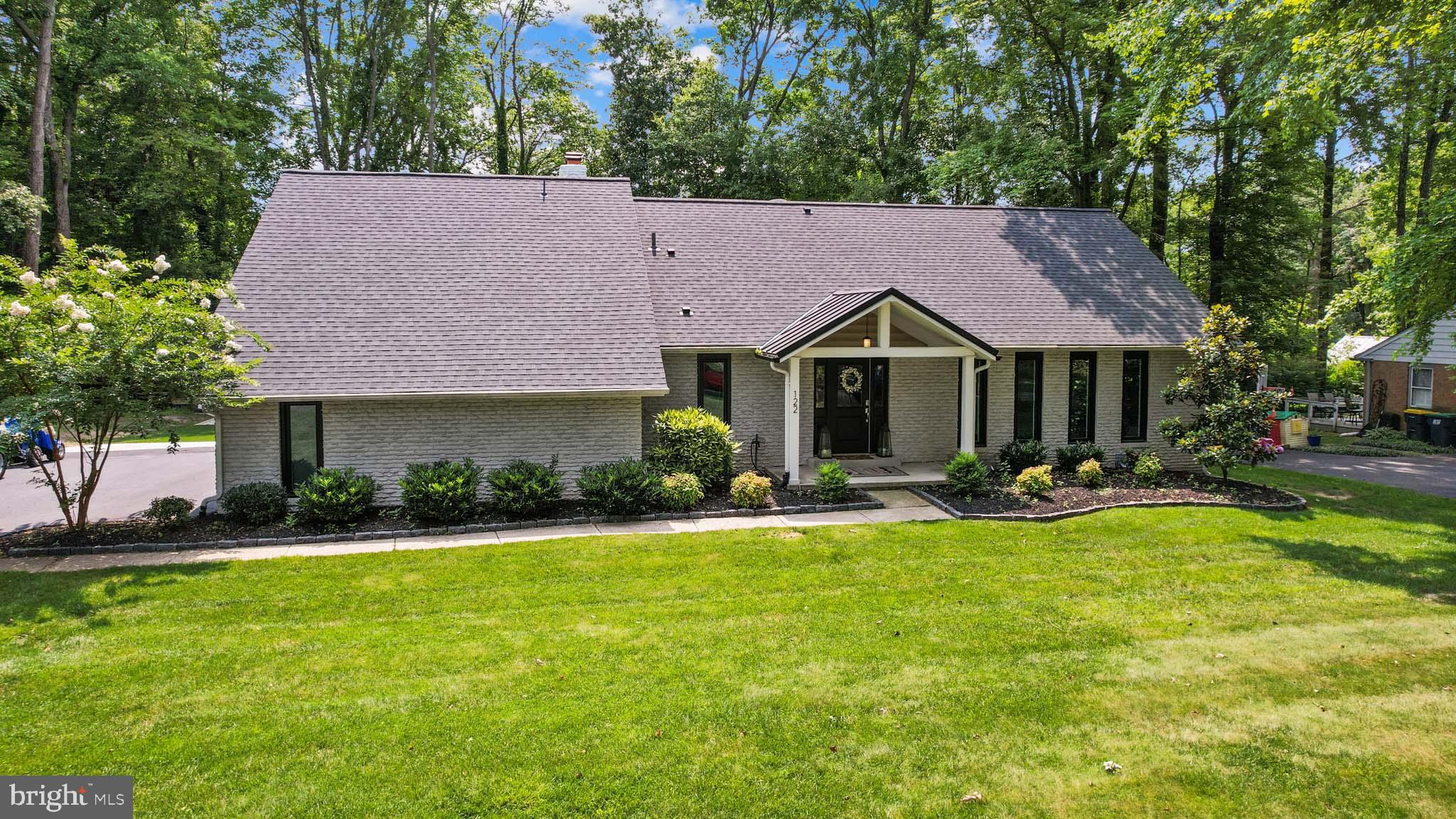 a front view of a house with a yard and trees