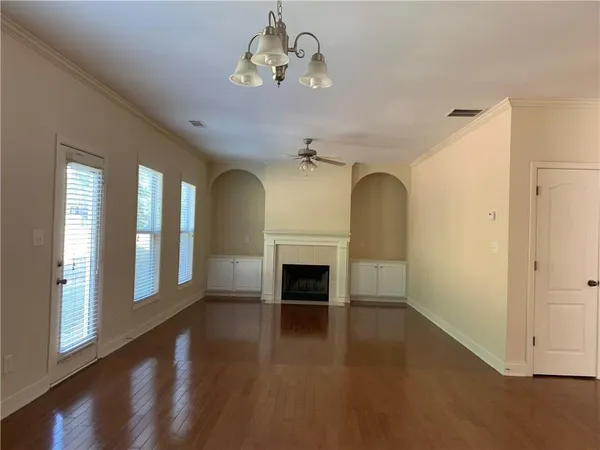 a view of a livingroom with a fireplace wooden floor and windows