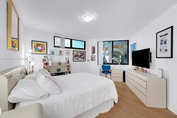 a bedroom with a bed and paintings on the wall
