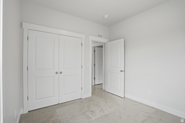 384 West Chadam Way, Unit 65 Midvale, UT 84047 - Photo 22 of 30 Unfurnished bedroom featuring light carpet and a closet