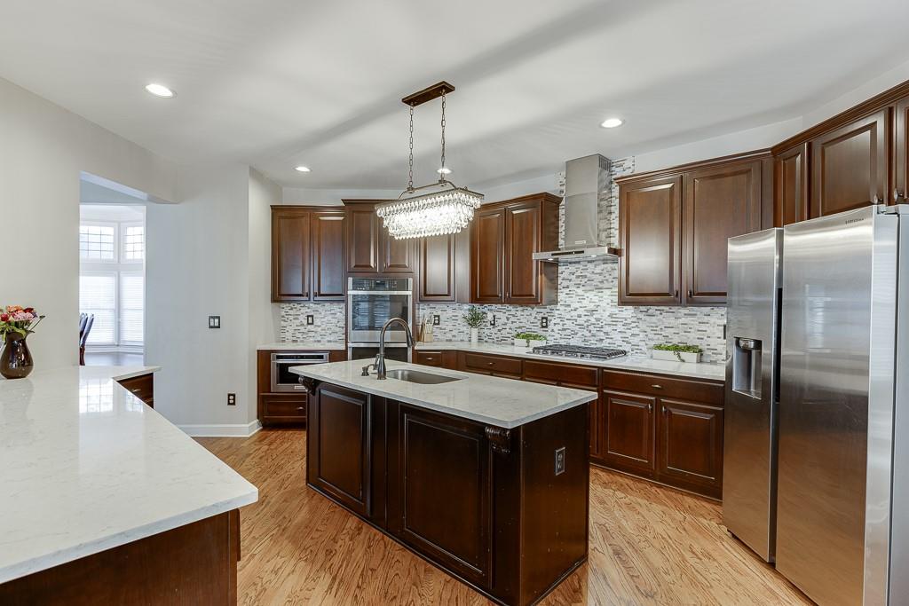 1806 Asteria Court Duluth, GA 30097 - Photo 16 of 63 a kitchen with stainless steel appliances granite countertop a sink a stove and a refrigerator