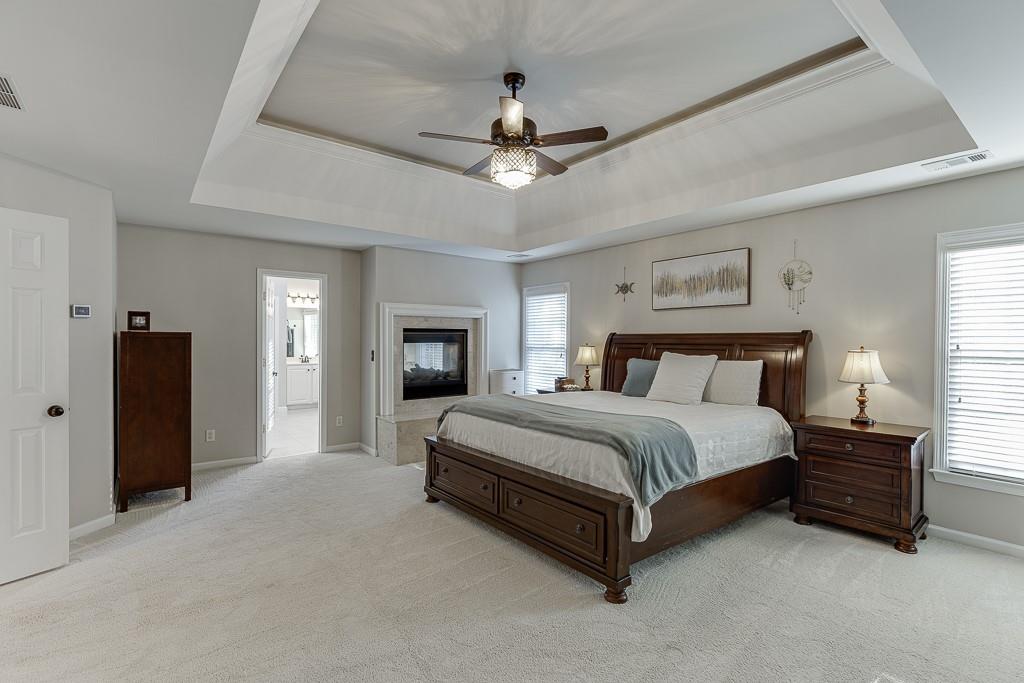 1806 Asteria Court Duluth, GA 30097 - Photo 28 of 63 a spacious bedroom with a bed chandelier and a window