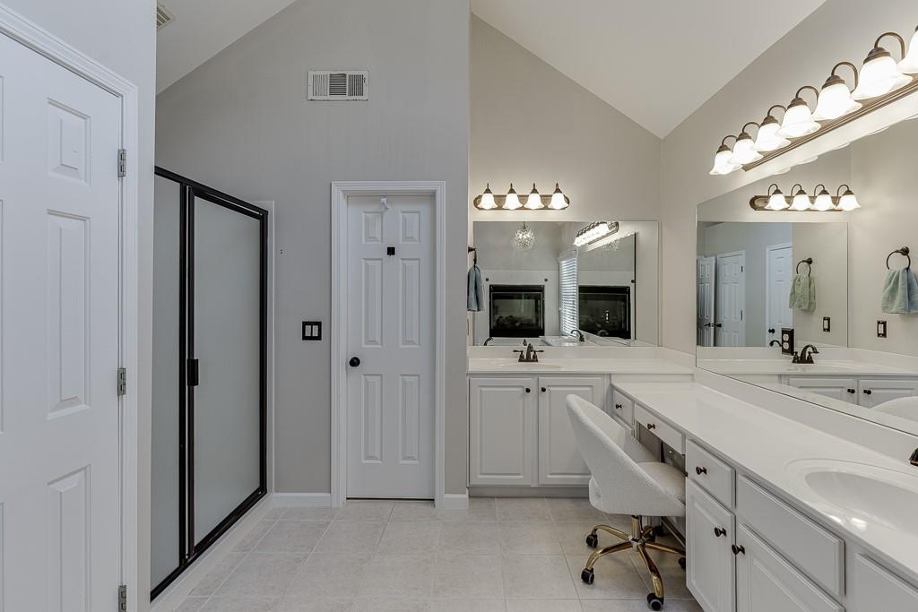 1806 Asteria Court Duluth, GA 30097 - Photo 32 of 63 a spacious bathroom with a granite countertop sink a mirror and a bathtub