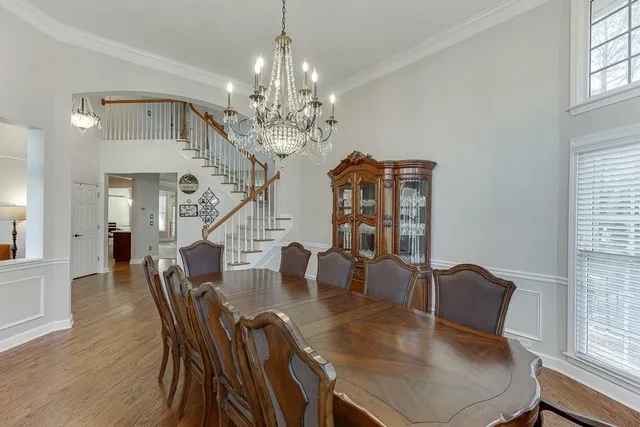 a view of a dining room with furniture a chandelier and wooden floor
