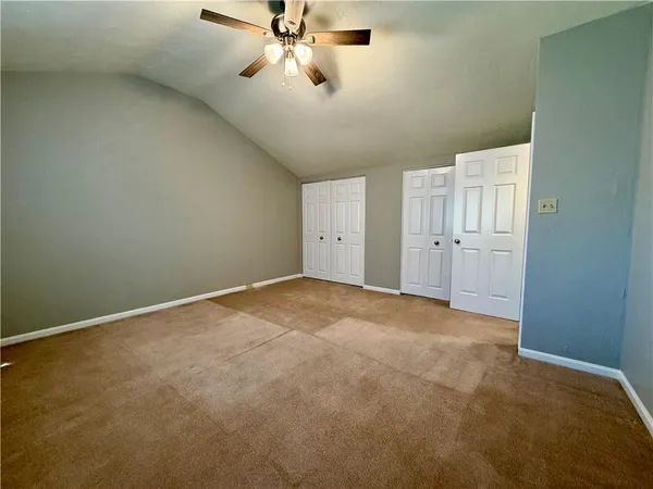 an empty room with a ceiling fan and a window
