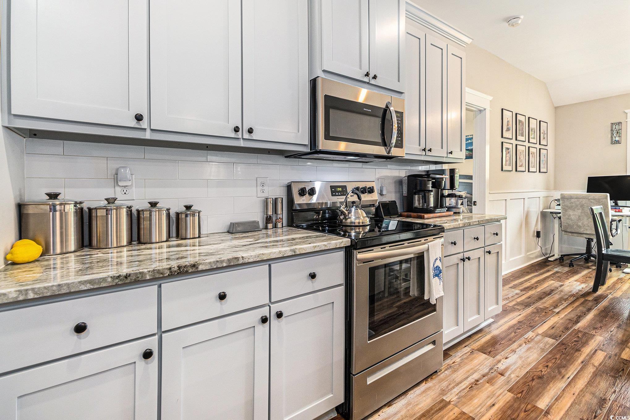 2895 Graham Road Conway, SC 29526 - Photo 12 of 31 Kitchen with stainless steel appliances, a wainscoted wall, light wood finished floors, a decorative wall, and light stone counters