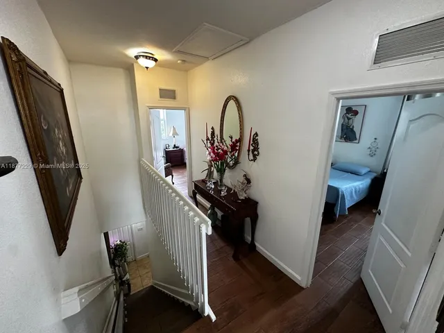 a view of a hallway with wooden floor and stairs