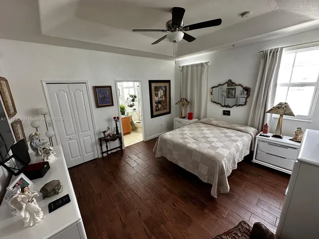 a bedroom with a bed a couch and wooden floor