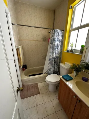 a bathroom with a sink a toilet a mirror and shower