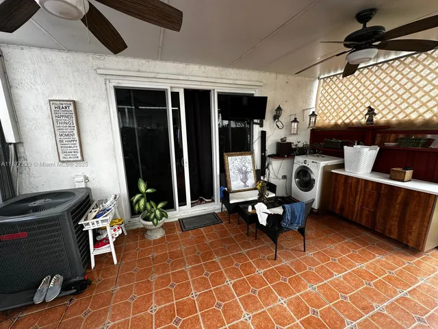 a living room with furniture a flat screen tv and floor to ceiling window