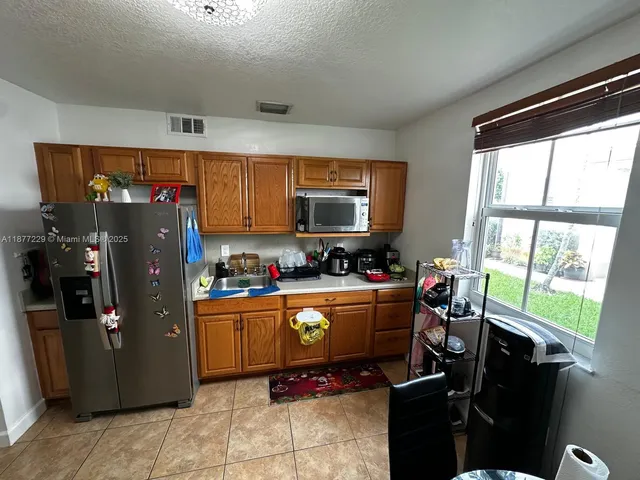 a room with furniture a flat screen computer and a refrigerator