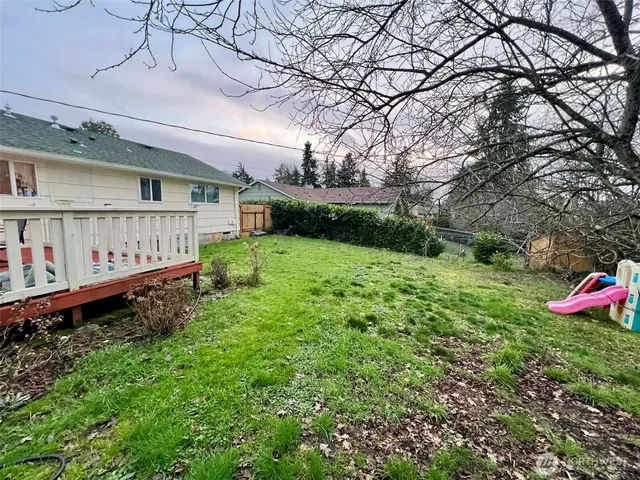 a view of an house with backyard space and deck