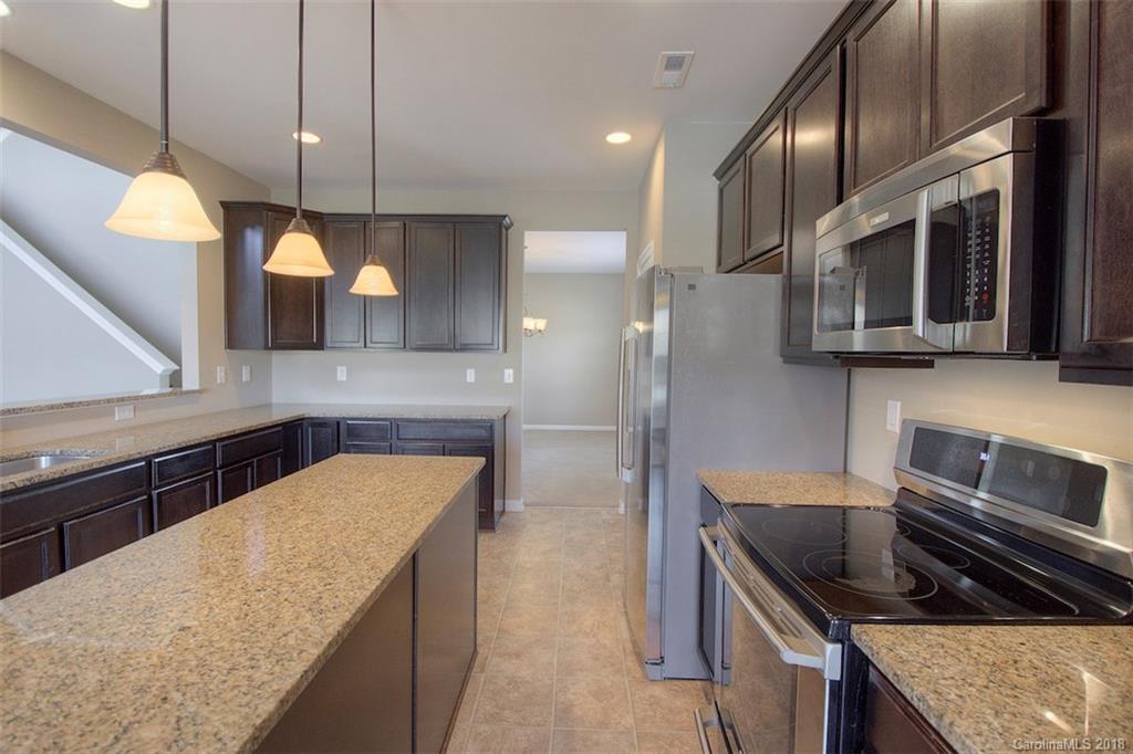2001 Spring Rose Lane Wesley Chapel, NC 28104 - Photo 22 of 36 a kitchen with stainless steel appliances granite countertop a sink and a stove