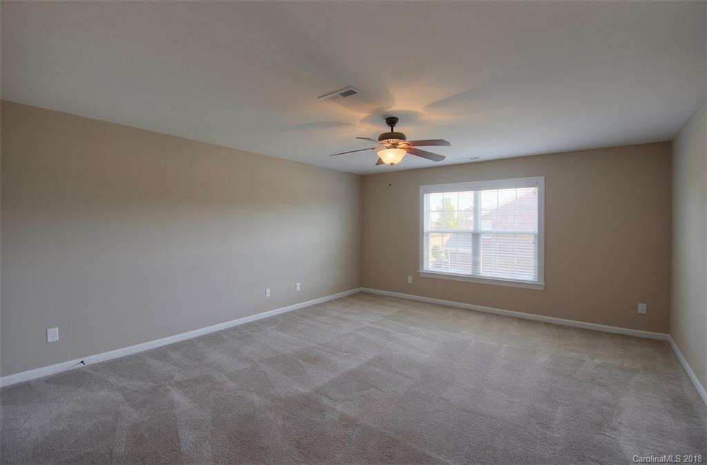 2001 Spring Rose Lane Wesley Chapel, NC 28104 - Photo 32 of 36 an empty room with chandelier fan and windows