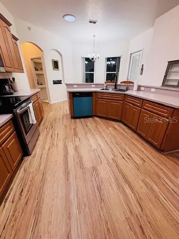 a kitchen with stainless steel appliances wooden floors and wooden cabinets