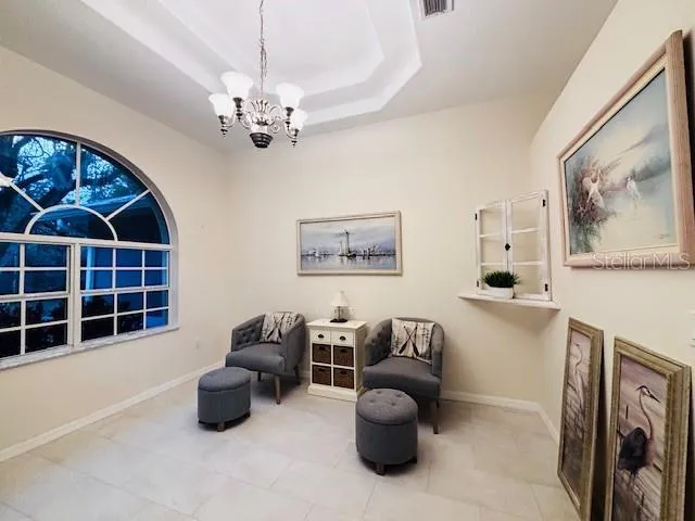 a living room with furniture a chandelier and a window