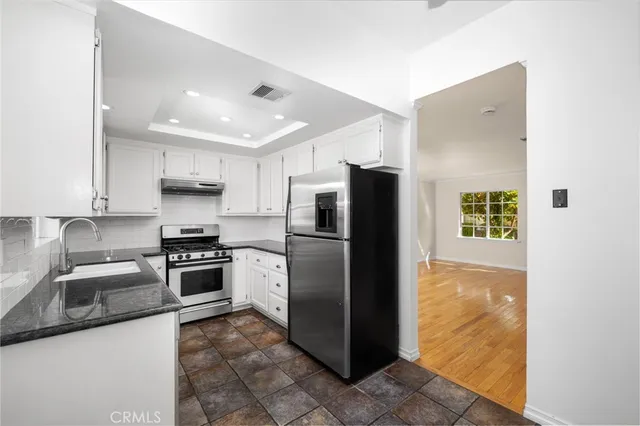 a kitchen with a sink stainless steel appliances and cabinets